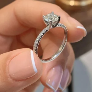 Elegant solitaire diamond ring with a sparkling round stone and slim silver band held in hand